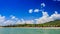 close view of green hilly island cloud shadows against blue sky