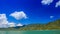 close view of green hilly island cloud shadows against blue sky