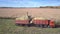 Close view harvester with truck drives gathering corn mass