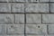 Close view of light gray unpainted brick veneer wall