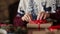 Close view of man`s hands tying a bow on a gifts for Christmas near fireplace, wrapping boxes, decorating with fir