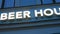 Close view: Modern BEER HOUSE illuminated sign on a pub's facade