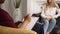 Close view of psychologist writing and woman talking while sitting on sofa in modern office spbas.