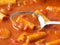Close view of rigatoni pasta and sausage with a spoon side view