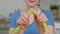 Close view smiling girl in blue t-shirt breaks celery stalk