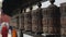 A close view of spinning buddhist prayer wheels in a row of wheels in Nepal Kathmandu. Temple.