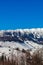 Close view of sunlit Bucegi mountains ridge with steep slopes covered by snow at sunrise, Carpathians mountains range, Romania