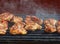 Close view of tasty marinated chicken breast fillets with seasonal spices on grill.