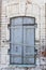 Closed antique wooden window in a white brick wall.