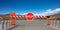 Closed barrier gate and stop sign, blue sky background. 3d illustration