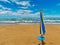 Closed big umbrella on the beach at summer in a windy day