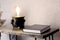 Closed black book Holy Bible on the table. Loft style lamp. In room. Desktop. Office.