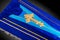 Closed blue coffin covered with cloth isolated on gray background. coffin close-up with gold Church cross.