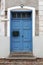 Closed blue door with the mailbox in a stone house