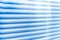 Closed blue shutters, macro shot. Jalousie background. Sunlight through horizontal blinds