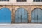 Closed blue weathered wooden arched doors in stone bricks wall, located in old abandoned district