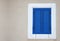 Closed blue window on white stucco wall, with vintage wooden jalousie, front view