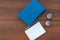 Closed book, eyeglasses, notepad and pen on wooden background