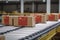 Closed cardboard boxes on conveyor belt with Chinese flag marking, generative AI.