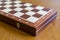 Closed checkerboard close-up. Closed chessboard for chess game on wooden table