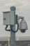 Closed-circuit camera on electric pole with walkway.