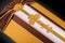 Closed coffin covered with brown and beige cloth decorated with Church gold cross on gray luxury background. Close-up.