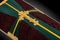 Closed coffin covered with brown and green cloth decorated with Church gold cross on gray luxury background. Close-up.