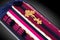 Closed coffin covered with pink and blue cloth decorated with Church gold cross on gray luxury background. Close-up.