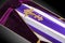 Closed coffin covered with purple and white cloth decorated with Church gold cross on gray luxury background. Close-up.