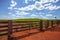 Closed farm gate under blue sky with clouds