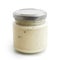 Closed glass jar of white garlic and herb sauce. in low