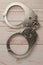 Closed handcuffs lie on a wooden background. Top view. The concept of sexual games