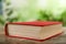 Closed hardcover book on table against blurred background