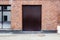 Closed metal doorway painted brown on red brick wall backgrounds