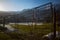 Closed mountain border, snow melts, lock on the fence, green grass