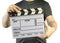 Closed movie clapper board in a man hands  on a white background