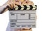 Closed movie clapper board in woman hands on a white background