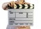 Closed movie clapper board in woman hands on a white background