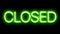 Closed neon sign appear on black background.