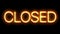 Closed neon sign appear on black background.