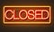 Closed neon sign on brick wall background.