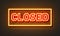 Closed neon sign on brick wall background.