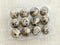 Closed package with twelve spotted quail eggs in a transparent plastic packaging. A dozen raw quail eggs on a beige textile