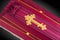 Closed pink coffin covered with cloth on gray background. coffin close-up with gold Church cross.