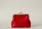 A closed red coin purse on a white background with a space for copying