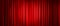 Closed red theater stage curtain with spotlight.