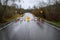 Closed road due to rainfall flooding over the roadway, barricades, empty road, stormy sky