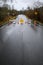 Closed road due to rainfall flooding over the roadway, barricades, empty road, stormy sky