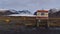 Closed road to SvinafellsjÃ¶kull with rockslide warning sign in winter with glacier SkaftafellsjÃ¶kull and snow-covered mountains.