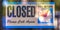 Closed sign with clock icon on a glass door